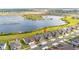 Aerial view of homes near a serene lake with a marker indicating the property location at 3256 Canna Lily Pl, Clermont, FL 34711