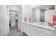 Bathroom featuring double sinks, white cabinetry, and a glass-enclosed shower at 3256 Canna Lily Pl, Clermont, FL 34711