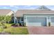 Charming one-story home with brick driveway and lush landscaping creates inviting curb appeal at 3256 Canna Lily Pl, Clermont, FL 34711