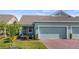 Charming single-story home with a two-car garage, brick driveway and well-manicured landscaping at 3256 Canna Lily Pl, Clermont, FL 34711