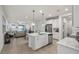 Open-concept kitchen with island, stainless steel appliances, flowing into the living area with lake views at 3256 Canna Lily Pl, Clermont, FL 34711