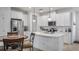 Bright kitchen featuring white cabinets, a central island, stainless steel appliances, and modern fixtures at 3256 Canna Lily Pl, Clermont, FL 34711
