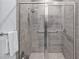 Walk-in shower with gray tile and glass enclosure at 3256 Canna Lily Pl, Clermont, FL 34711