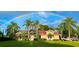 Charming home featuring lush lawn, palm trees, and a vibrant rainbow overhead at 3511 Fox Lake Dr, Apopka, FL 32712