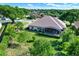 Aerial view of a private backyard with a screened lanai, mature trees, and lush landscaping at 39705 Grove Hts, Lady Lake, FL 32159