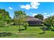 Expansive backyard featuring a screened-in lanai, lush lawn, and mature trees at 39705 Grove Hts, Lady Lake, FL 32159