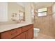 Bathroom featuring a wood vanity cabinet, modern sink, and a tiled shower with glass doors at 39705 Grove Hts, Lady Lake, FL 32159