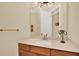 Well-lit half bath with a wood vanity cabinet, modern sink and faucet, and decorative wall accents at 39705 Grove Hts, Lady Lake, FL 32159