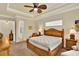 Comfortable bedroom featuring a ceiling fan, tray ceiling, and stylish wooden furniture at 39705 Grove Hts, Lady Lake, FL 32159