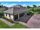 Aerial shot of a house featuring a spacious three-car garage and brick paved driveway at 39705 Grove Hts, Lady Lake, FL 32159