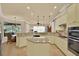 Light and airy kitchen with island, granite countertops, stainless appliances, tile floors, and pendant lighting at 39705 Grove Hts, Lady Lake, FL 32159