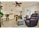 Inviting living room with tile floors, ceiling fan, and comfortable seating near an open kitchen bar at 39705 Grove Hts, Lady Lake, FL 32159