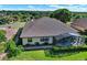 Aerial view of rear exterior featuring a screened-in lanai and well-manicured lawn at 39705 Grove Hts, Lady Lake, FL 32159