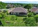 Aerial view of home's rear featuring a screened-in lanai and well-manicured lawn at 39705 Grove Hts, Lady Lake, FL 32159