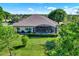 Aerial view of the house's rear exterior with screened-in lanai and pristine lawn at 39705 Grove Hts, Lady Lake, FL 32159