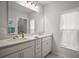 Bathroom features a double vanity with white countertops, ample cabinet space, and a large mirror at 444 Shadow Gorge Way, Eustis, FL 32736