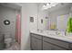 Bathroom has a double vanity with modern fixtures, a toilet, and a shower with a striped curtain at 444 Shadow Gorge Way, Eustis, FL 32736