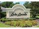 Elegant entrance sign for Lake Lincoln surrounded by colorful flowerbeds and greenery at 444 Shadow Gorge Way, Eustis, FL 32736