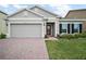 Charming single-Gathering home featuring a two-car garage, red brick driveway, and well-manicured landscaping at 444 Shadow Gorge Way, Eustis, FL 32736