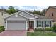 Charming single-story home featuring a brick walkway, gray stucco, and well-maintained landscaping at 444 Shadow Gorge Way, Eustis, FL 32736