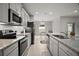 Kitchen with granite counters, subway tile backsplash, and stainless steel appliances overlooking dining area at 444 Shadow Gorge Way, Eustis, FL 32736