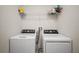 Laundry room with modern washer and dryer, plus storage shelves for convenience and organization at 444 Shadow Gorge Way, Eustis, FL 32736