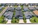 An aerial view reveals single-story homes with attached garages, fenced yards, and well manicured lawns at 449 Gilson Loop, The Villages, FL 32163