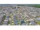 An aerial photo of a suburban neighborhood with lush lawns, and tidy streets; serene ponds add natural beauty at 449 Gilson Loop, The Villages, FL 32163