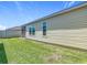 Home exterior view featuring a well-maintained lawn and screened-in patio area at 449 Gilson Loop, The Villages, FL 32163