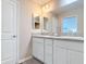 Bathroom featuring double sinks, modern vanity, and a large mirror, offering a spa-like experience at 449 Gilson Loop, The Villages, FL 32163