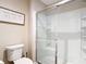 Well-maintained bathroom with a glass-enclosed shower, toilet, and decorative wall art at 449 Gilson Loop, The Villages, FL 32163