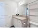 Well-lit bathroom with vanity, ample counter space, decorative mirror, and storage shelves for toiletries at 449 Gilson Loop, The Villages, FL 32163