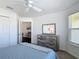 Inviting bedroom boasts a modern rustic dresser, ceiling fan, and a glimpse into an adjacent room at 449 Gilson Loop, The Villages, FL 32163