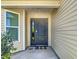 Close-up of the front door with a side window and covered entrance at 449 Gilson Loop, The Villages, FL 32163