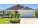 Attractive single-story home with a two-car garage and manicured shrubs at 449 Gilson Loop, The Villages, FL 32163