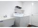 Functional laundry room with a utility sink, modern washer and dryer, and convenient shelving at 449 Gilson Loop, The Villages, FL 32163