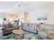 Bright, open living room featuring plush seating, ceiling fan, and seamless flow to the modern white kitchen at 449 Gilson Loop, The Villages, FL 32163