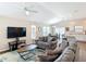 Open-concept living room with plush seating, a ceiling fan, and a view of the dining area and kitchen at 449 Gilson Loop, The Villages, FL 32163