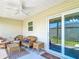 Cozy screened lanai featuring comfortable seating, a ceiling fan, and access to the backyard at 449 Gilson Loop, The Villages, FL 32163