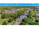 An aerial view of a neighborhood near a lush wooded area and pond, showcasing backyards and screened in pools at 5138 Rishley Run Way, Mount Dora, FL 32757