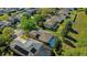 An aerial view of a neighborhood featuring lush greenery, swimming pools, and well-maintained homes at 5138 Rishley Run Way, Mount Dora, FL 32757