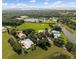 Expansive aerial view displays a community pool, clubhouse, and tennis courts, enveloped by lush trees and green lawns at 5138 Rishley Run Way, Mount Dora, FL 32757