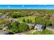 An aerial view showcases a residential area with houses, green spaces, and a pond, offering a scenic overview of the neighborhood at 5138 Rishley Run Way, Mount Dora, FL 32757