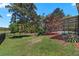 Expansive backyard featuring a screened-in pool, lush lawn, and mature trees, perfect for outdoor enjoyment at 5138 Rishley Run Way, Mount Dora, FL 32757