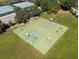 Aerial view of a full-sized outdoor basketball court featuring multiple hoops, lighting, and surrounded by green space at 5138 Rishley Run Way, Mount Dora, FL 32757