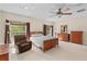 Bright bedroom featuring a ceiling fan, natural light, and wood furniture at 5138 Rishley Run Way, Mount Dora, FL 32757
