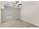 Neutral bedroom featuring a ceiling fan, plush carpeting, and natural light from a window at 5138 Rishley Run Way, Mount Dora, FL 32757