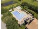 Aerial view of a community pool featuring lounge chairs, tables, fountain, and lush landscaping creating an inviting outdoor space at 5138 Rishley Run Way, Mount Dora, FL 32757