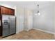 Kitchen with stainless steel refrigerator, dark cabinetry, and tile flooring at 5138 Rishley Run Way, Mount Dora, FL 32757