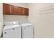 Laundry room featuring a washer, dryer, overhead cabinet, and wire rack at 5138 Rishley Run Way, Mount Dora, FL 32757